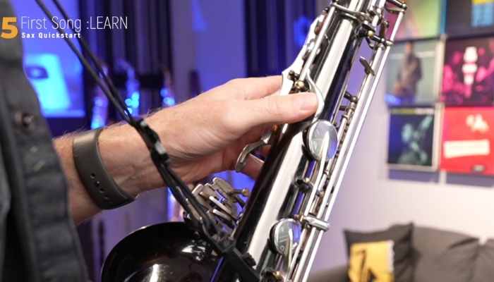 Hold the saxophone with left thumb on the button . Sax School Online